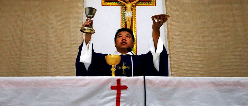 FILE PHOTO: Catholic priest Liu Yong Wang performs holy communion in a make-shift chapel in the village of Bai Gu Tun, located on the outskirts of the city of Tianjin, around 70 km (43 miles) south-east of Beijing July 17, 2012.Reuters/File Photo