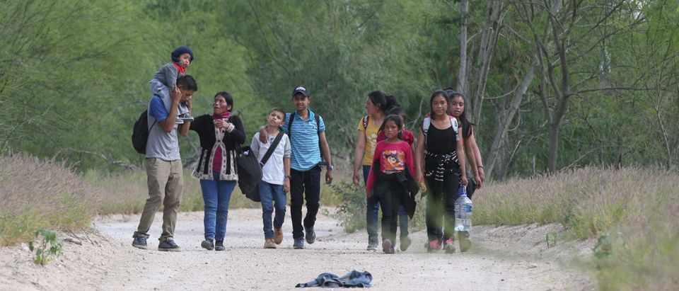 People who illegally crossed the Mexico-U.S. border walk up a dirt road near McAllen