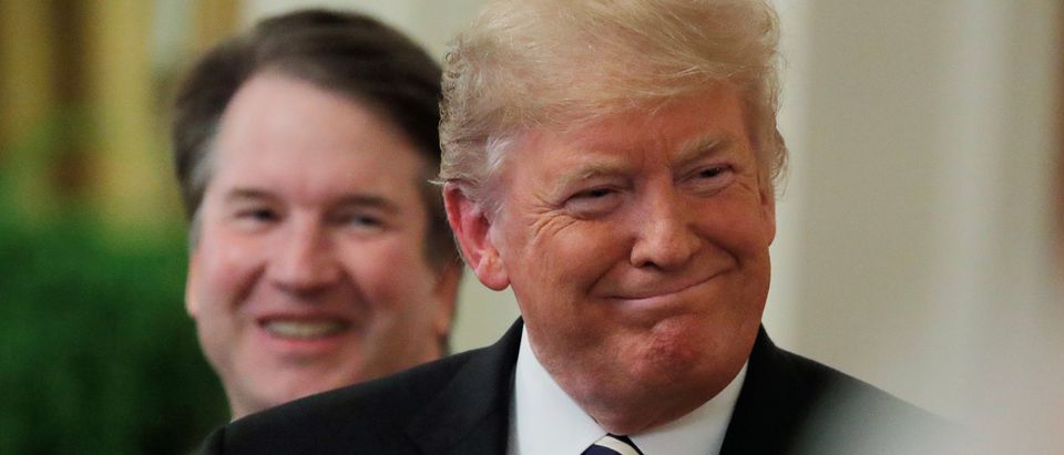 President Donald Trump smiles next to U.S. Supreme Court Associate Justice Brett Kavanaugh as they participate in a ceremonial public swearing-in in the East Room of the White House in Washington, October 8, 2018. REUTERS/Jim Bourg