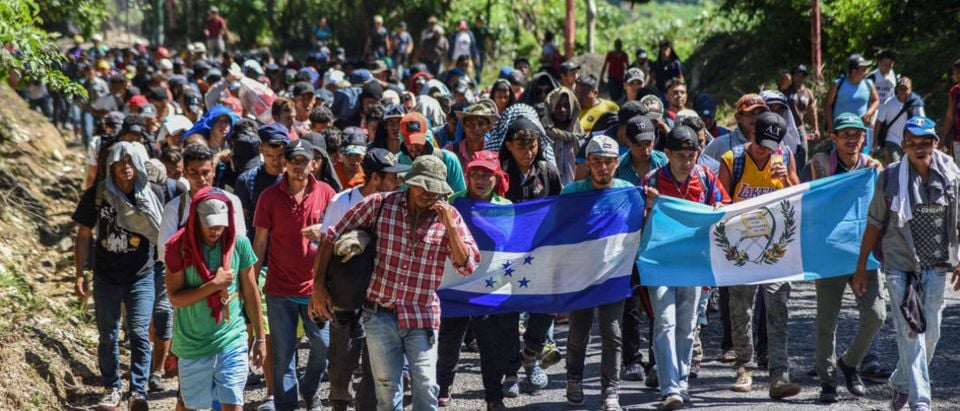 Honduran migrants take part in a new caravan heading to the US with Honduran and Guatemalan national flags in Quezaltepeque, Chiquimula, Guatemala on Oct/ 22, 2018. -- U.S. President Donald Trump on Monday called the migrant caravan heading toward the US-Mexico border a national emergency, saying he has alerted the U.S. border patrol and military. (Photo by ORLANDO ESTRADA / AFP)