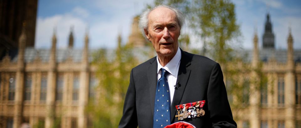 FILE PHOTO: World War Two Norwegian resistance fighter Joachim Roenneberg holds up a Union flag, which had been lowered from above the House of Lords, after it was presented to him by the Clerk of the House of Lords in Westminster, London, April 25, 2013. REUTERS/Andrew Winning