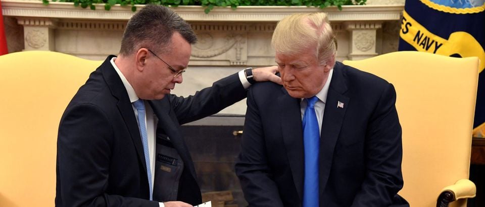 U.S. President Donald Trump closes his eyes in prayer along with Pastor Andrew Brunson, after his release from two years of Turkish detention, in the Oval Office of the White House, Washington, U.S., October 13, 2018. REUTERS/Mike Theiler