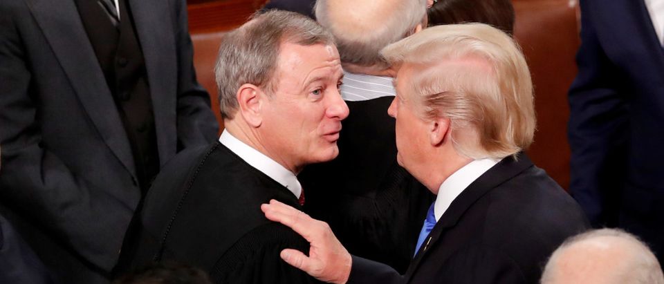 FILE PHOTO: U.S. President Donald Trump (R) talks with U.S. Supreme Court Chief Justice John Roberts as he departs after delivering his State of the Union address to a joint session of the U.S. Congress on Capitol Hill in Washington, U.S. January 30, 2018. REUTERS/Jonathan Ernst/File Photo