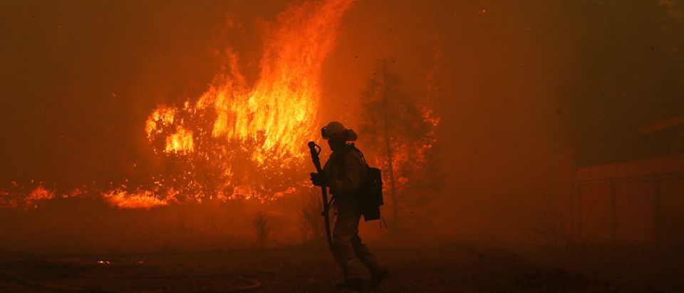 A Cal Fire firefighter monitors a fire near a home while battling the Camp Fire in Paradise, California, U.S. Nov. 8, 2018. REUTERS/Stephen Lam