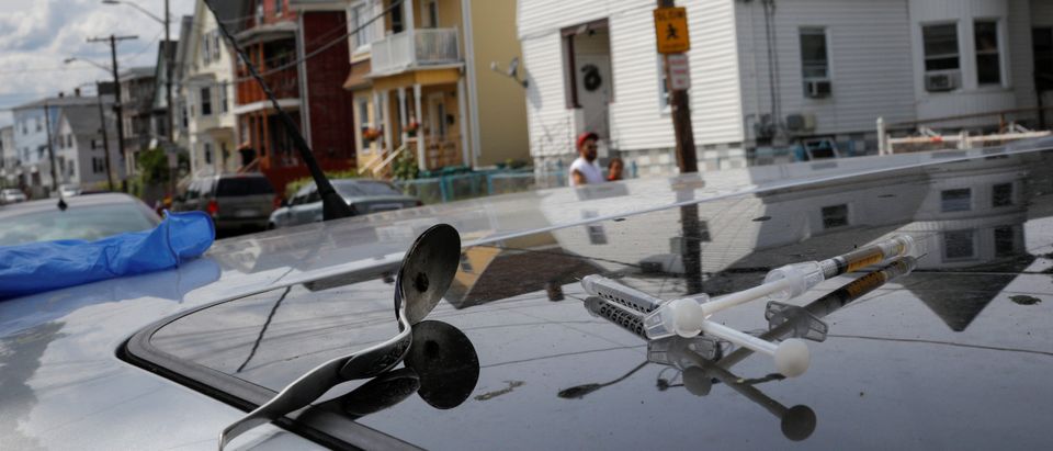 A full syringe, empty syringe and spoon sit on the roof of the car in which a man in his 20's overdosed on an opioid in the Boston suburb of Lynn. REUTERS/Brian Snyder