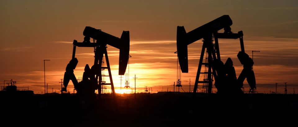 Pump jacks operate at sunset in an oil field in Midland