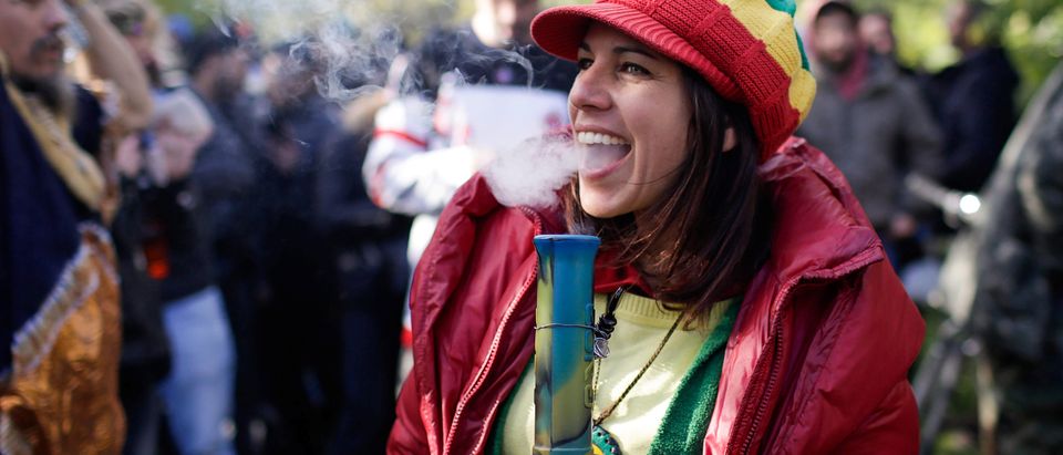 A woman smokes a bong on the day Canada legalizes recreational marijuana at Trinity Bellwoods Park
