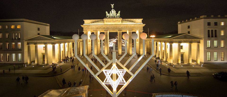 BERLIN, GERMANY - DECEMBER 16: The first lamp of a large scale menorah in front of the Brandenburg Gate lights after it was lights by Rabbis Yehuda Teichtal and German Interior Minist Lothar de Maiziere on December 16, 2014 in Berlin, Germany. It is the first day in the celebration of Hanukkah. Berlin is home to a growing Jewish population, many of whom are immigrants from the former Soviet Union, after the local Jewish community was devastated by the Holocaust before and during World War II. (Photo by Carsten Koall/Getty Images)