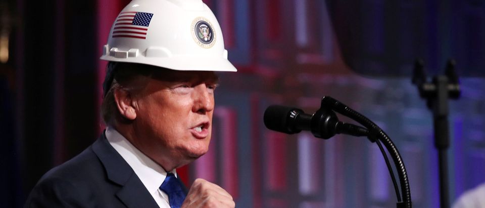 U.S. President Donald Trump dons a hard hat presented by the National Electrical Contractors Association (NECA) before addressing their convention in Philadelphia, Pennsylvania, U.S., October 2, 2018. REUTERS/Jonathan Ernst