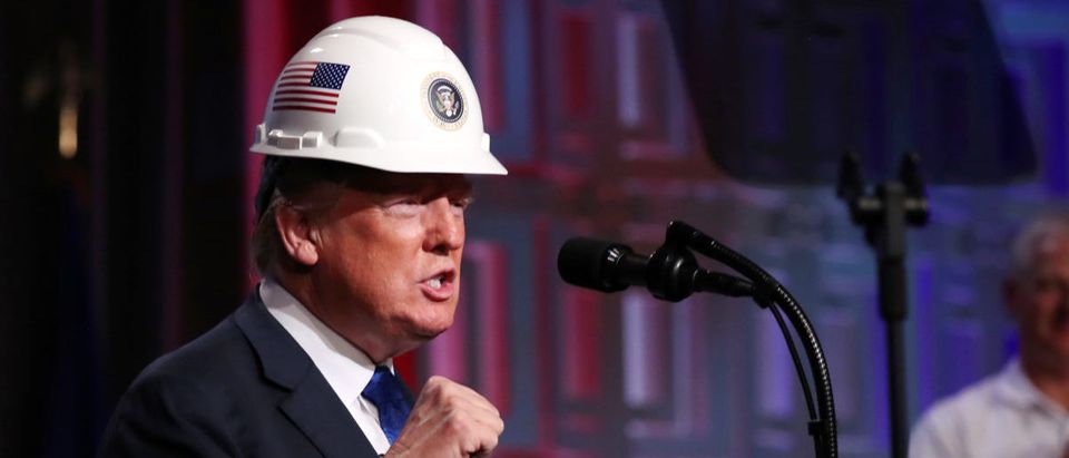 U.S. President Donald Trump dons a hard hat presented by the National Electrical Contractors Association (NECA) before addressing their convention in Philadelphia, Pennsylvania, U.S., Oct. 2, 2018. REUTERS/Jonathan Ernst