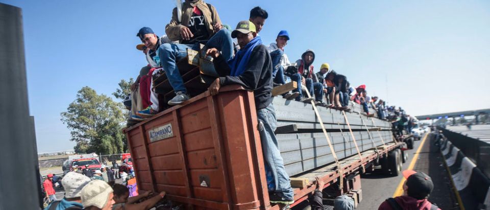 Central American migrants -- mostly Honduran -- taking part in a caravan to the US, are pictured on board a truck heading to Irapuato in the state of Guanajuato on Nov. 11, 2018 after spending the night in Queretaro in central Mexico. (Photo by ALFREDO ESTRELLA / AFP)