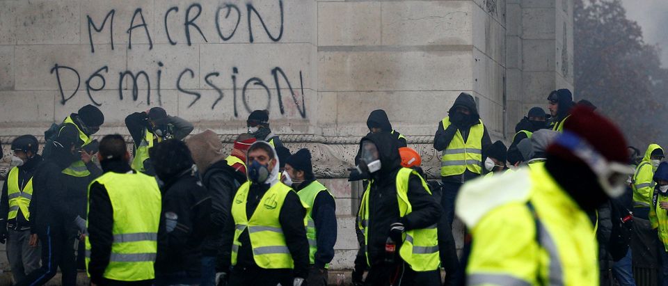 The message "Macron Resign" is seen on the Arc de Triomphe as protesters wearing yellow vests, a symbol of a drivers' protest against higher diesel taxes, demonstrate at the Place de l'Etoile in Paris