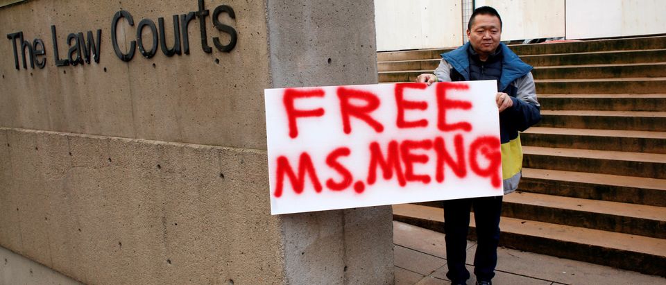 FILE PHOTO: A man holds a sign outside of the B.C. Supreme Court bail hearing of Huawei CFO Meng Wanzhou, who is being held on an extradition warrant in Vancouver
