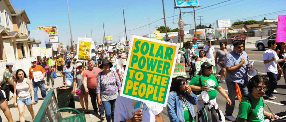 Demonstrators walk on the Pacific Coast highway during People's Climate March protest for the environment in the Wilmington neighborhood in Los Angeles, California, U.S. April 29, 2017. The march, which specifically protested the expansion of a Tesoro refinery, was held in a heavily industrialized neighborhood and was led by environmental leaders from the indigenous and minority communities. REUTERS/Andrew Cullen