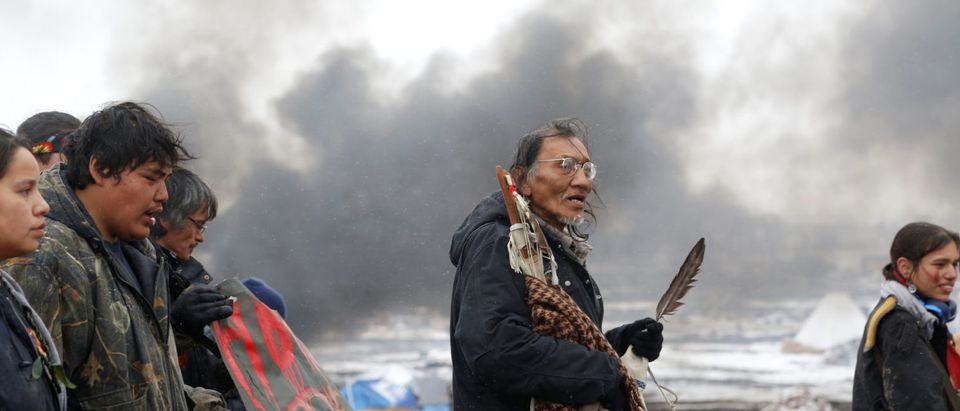 Nathan Phillips (C) marches with other protesters out of the main opposition camp against the Dakota Access oil pipeline near Cannon Ball, North Dakota, U.S., February 22, 2017. Picture taken February 22, 2017. REUTERS/Terray Sylvester