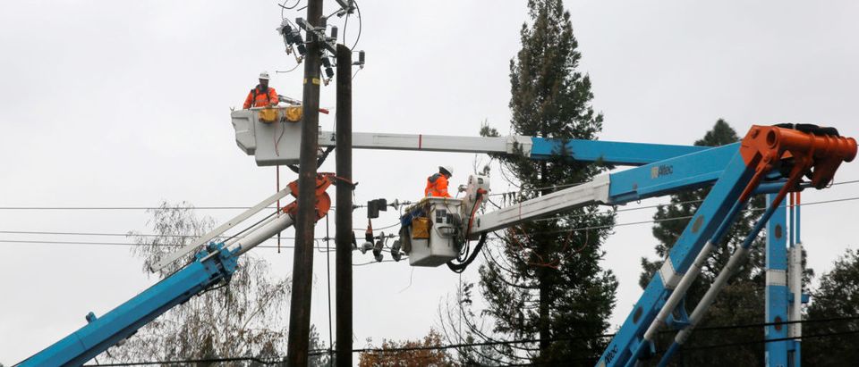 PG&E crew work on power lines to repair damage caused by the Camp Fire in Paradise, California, U.S. November 21, 2018. REUTERS/Elijah Nouvelage