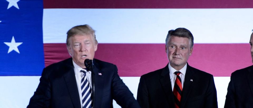 US House candidate from North Carolina Mark Harris (C) and Rep. Ted Budd (R) listen to US President Donald Trump speech during a fundraiser at the Carmel Country Club August 31, 2018 in Charlotte, North Carolina. (BRENDAN SMIALOWSKI/AFP/Getty Images)