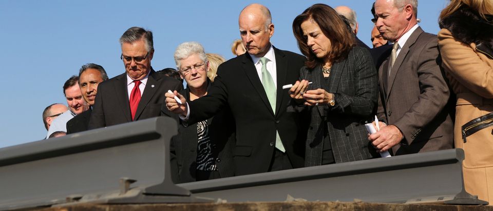 California Governor Jerry Brown and his wife, Anne Gust, prepare to sign a railroad rail during a ceremony for the California High Speed Rail in Fresno