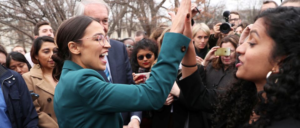 U.S. Rep. Alexandria Ocasio-Cortez and Sen. Ed Markey (obscured) celebrate with activists after a news conference for their proposed "Green New Deal" to achieve net-zero greenhouse gas emissions in 10 years, at the U.S. Capitol in Washington, Feb. 7, 2019. REUTERS/Jonathan Ernst