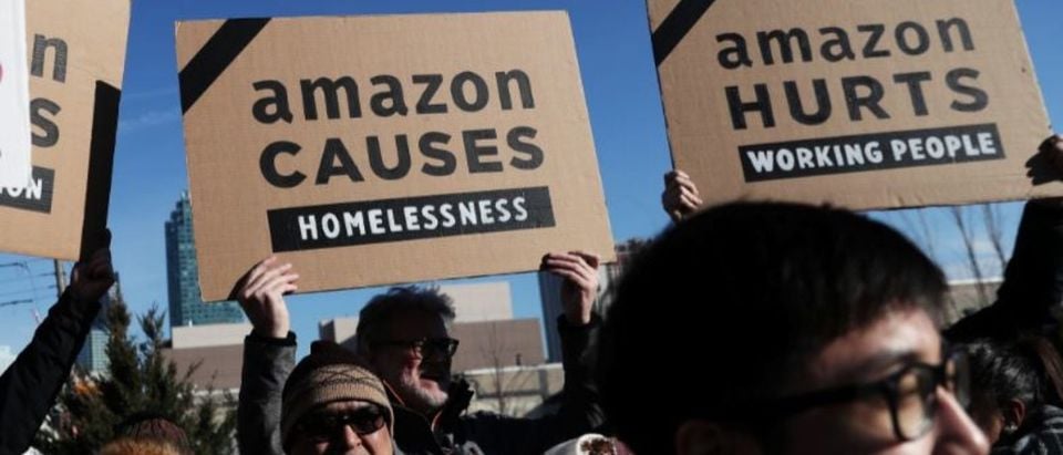 Demonstrators hold signs during a protest against Amazon in the Long Island City section of the Queens borough of New York, U.S., February 14, 2019. REUTERS/Shannon Stapleton