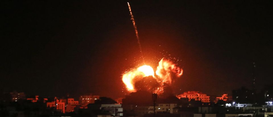 A ball of fire lights the sky above a building believed to house the offices of Hamas chief in Gaza, Ismail Haniyeh, during Israeli strikes on the Gaza City, on March 25, 2019. Photo by MAHMUD HAMS/AFP/Getty Images