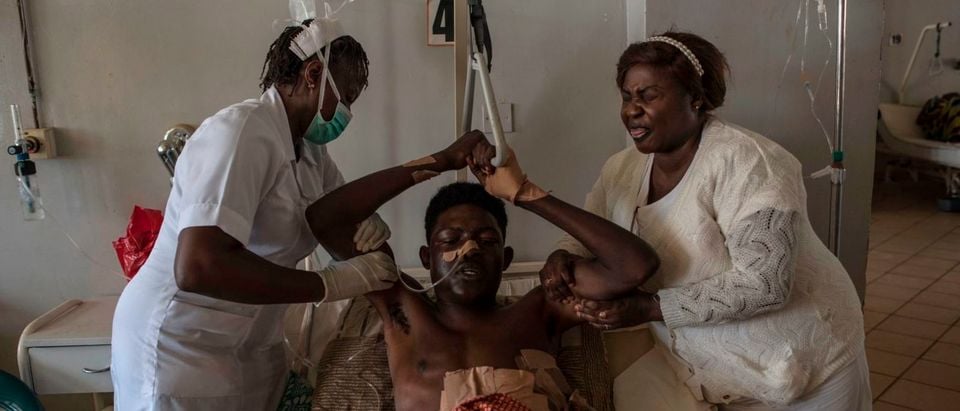 Nurses assist a man that sustained multiple stab wounds and machete cuts during the farmer-Fulani clashes to pull himself up at the Jos University Teaching Hospital on June 28, 2018. - Plateau State in Nigeria has seen days of violence where more than 200 people have been killed in clashes between Berom farmers and Fulani herders, Nigeria is facing an escalation in clashes between farmers and Fulani herders over land use and resources that is deepening along religious and ethnic lines. (STEFAN HEUNIS/AFP/Getty Images)