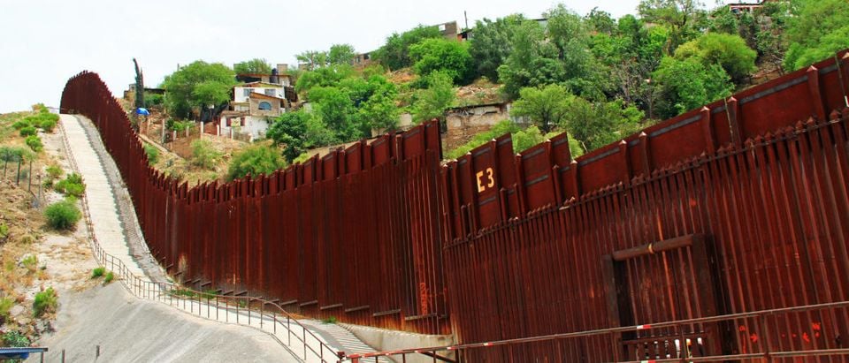 A border fence is pictured beside a street in downtown Nogales, Arizona, separating the United States from Mexico. Shutterstock