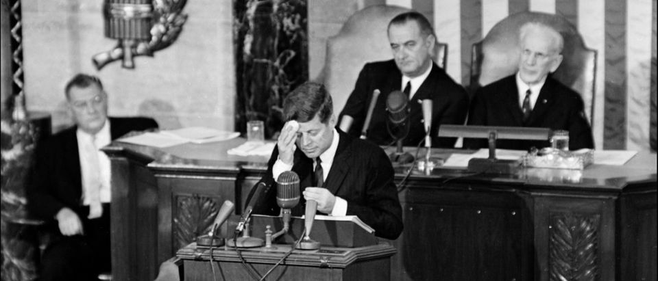 President Kennedy wipes his forehead as Vice President Lyndon B. Johnson looks on. AFP/AFP/Getty Images.
