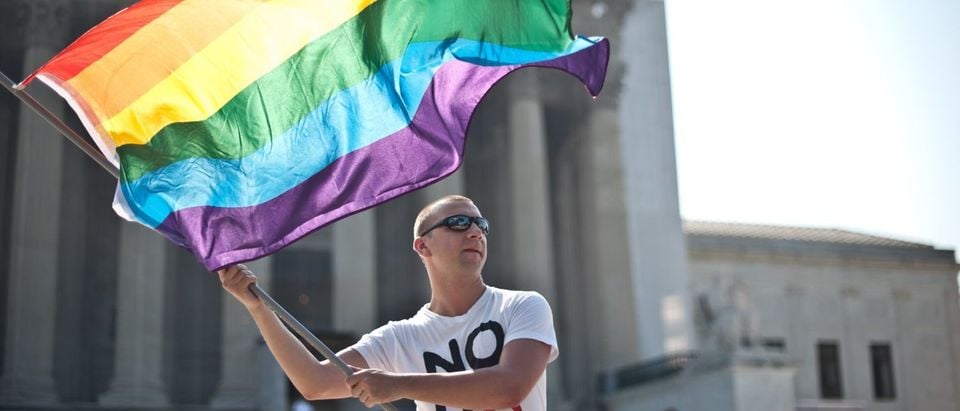 A gay rights activist waves a rainbow flag in front of the Supreme Court on June 25, 2013. (Nicholas Kamm/AFP/Getty Images)