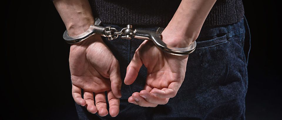 A man is in handcuffs. Shutterstock image via user pinholeimaging