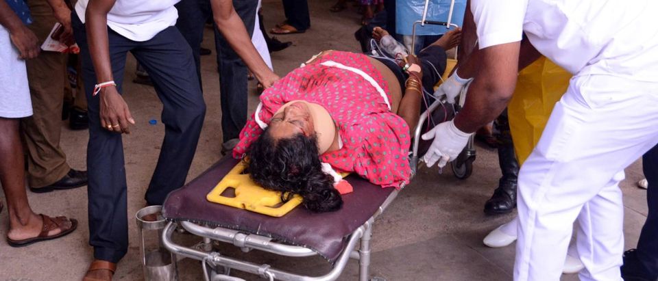 An injured Sri Lankan woman lays on a stretcher as hospital workers push her at the District General Hospital in Negombo, following an explosion at St Sebastian's Church, on April 21, 2019. (Photo credit should read STR/AFP/Getty Images)
