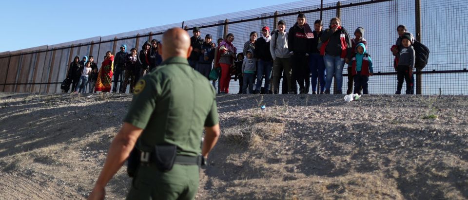 A group of Central American migrants surrenders to U.S. Border Patrol Agent Jose Martinez south of the U.S.-Mexico border fence in El Paso