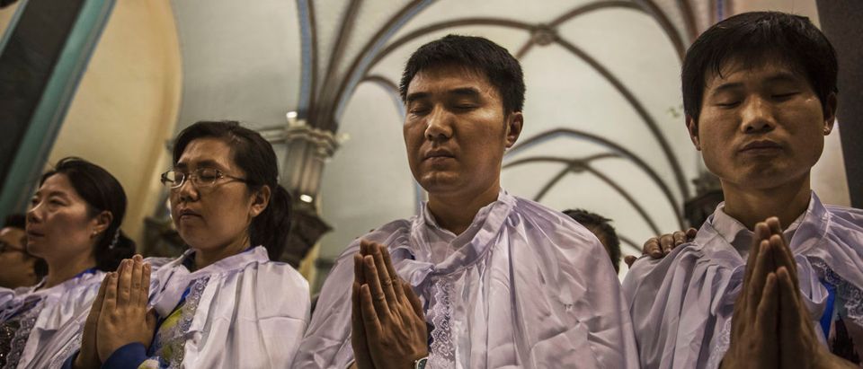 BEIJING, CHINA - APRIL 15: Newly baptized Chinese Catholic worshippers pray during a special ceremony at a mass on Holy Saturday during Easter celebrations at the government sanctioned West Beijing Catholic Church on April 15, 2017 in Beijing, China. China, an officially atheist country, places a number of restrictions on Christians, allowing legal practice of the faith only at state-approved churches. The policy has driven an increasing number of Christians and Christian converts 'underground' to congregations in private homes and other venues. While the size of the religious community is difficult to measure, studies estimate there are more than 80 million Christians inside China; some studies support the possibility it could become the most Christian nation in the world in the coming years. Officially there have been no relations between China and the Vatican since the country's modern founding in 1949 though in recent years there have been signs of warming relations between Chinese president Xi Jinping and Pope Francis that could possibly allow greater religious freedom in the future. At present, the split means approved Chinese Christians worship within a state-sanctioned Church known as the Patriotic Association which regards the Communist Party as its leader, not the Pope in Rome. (Photo by Kevin Frayer/Getty Images)