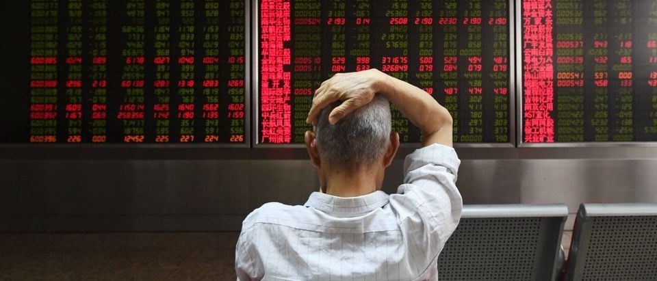 A man checks stock price movements at a securities company in Beijing on July 4, 2018. (GREG BAKER/AFP/Getty Images)