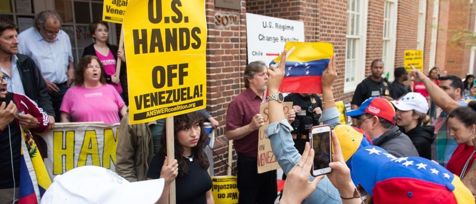 Supporters of Venezuelan opposition leader Juan Guaido hold a rally outside the Venezuelan Embassy in Washington, DC, April 30, 2019, as members of the US Secret Service Uniformed Division stand watch between them and activists opposed to Guaido. SAUL LOEB/AFP/Getty Images