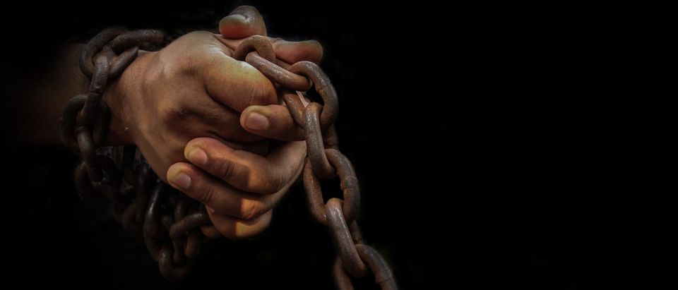 A slave's hands are in chains. Shutterstock image via Sanit Fuangnakhon