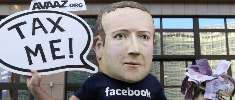 An activist wearing a mask depicting Facebook's CEO Mark Zuckerberg demonstrates during the European Union finance ministers meeting, outside the EU headquarters in Brussels, Belgium, Dec. 4, 2018. REUTERS/Yves Herman
