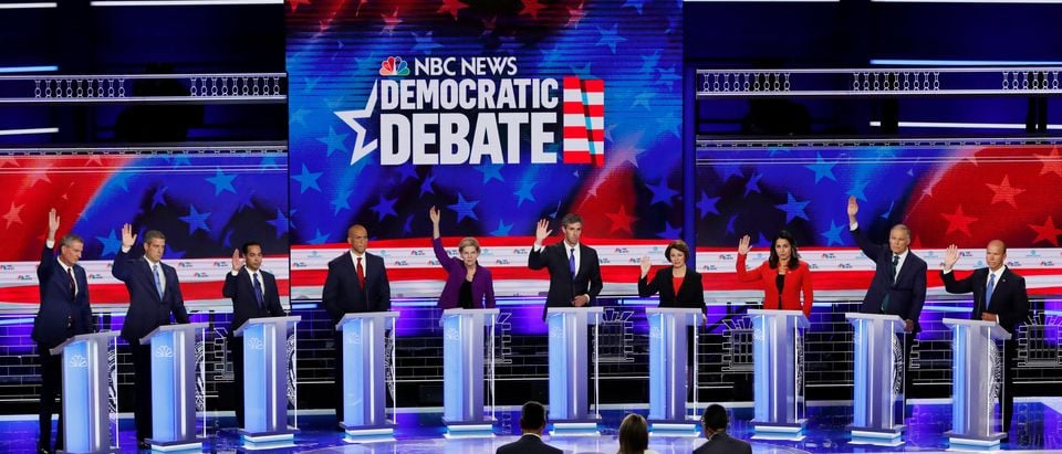 All candidates except U.S. Senator Cory Booker raise their hands while responding to a question that they would currently support the original Iran nuclear agreement during the first U.S. 2020 presidential election Democratic candidates debate in Miami, Florida, U.S., June 26, 2019. REUTERS/Mike Segar