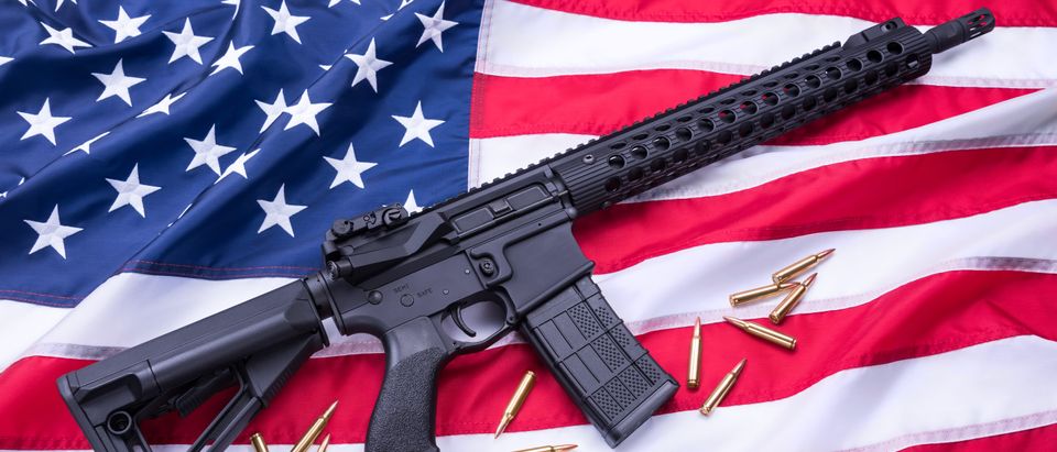 AR-15 sitting on an American flag with 5.56 caliber ammunition (Shutterstock)