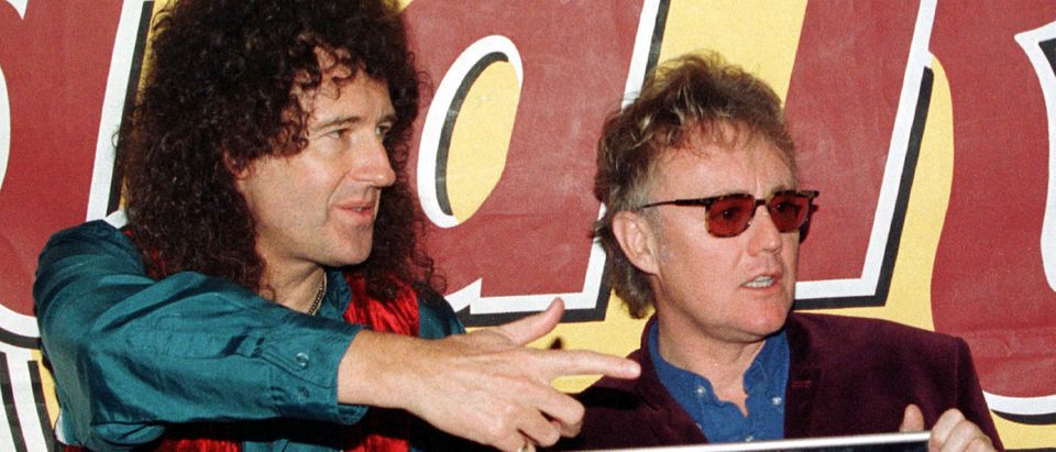 British pop group Queen's Brian May (L) and Roger Taylor gestures to photographers during their new long play "Queen Rocks" presentation in central Barcelona November 14. Queen yesterday received the "Ondas Award" for their contribution to pop music. Reuters/Gustau Nacarino