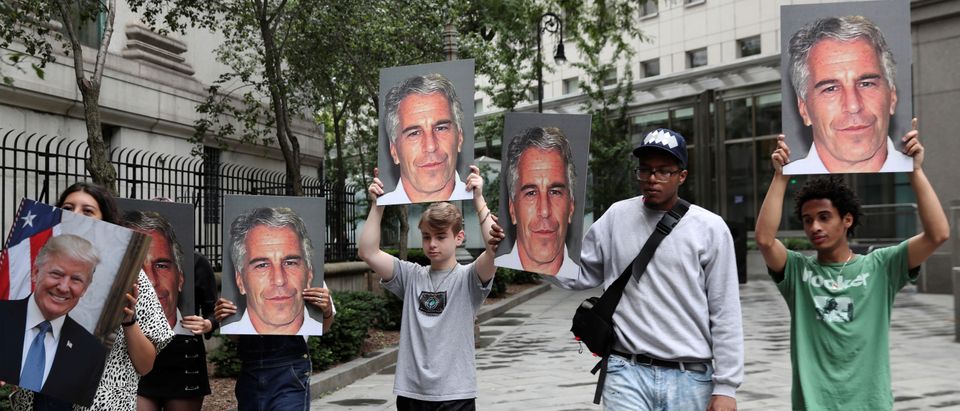 Demonstrators hold photos aloft protesting Jeffrey Epstein in New York