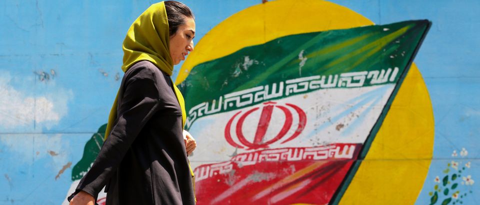A woman walks in front of a mural showing the Iranian national flag in the centre of the capital Tehran, on April 23, 2019. (ATTA KENARE/AFP/Getty Images)