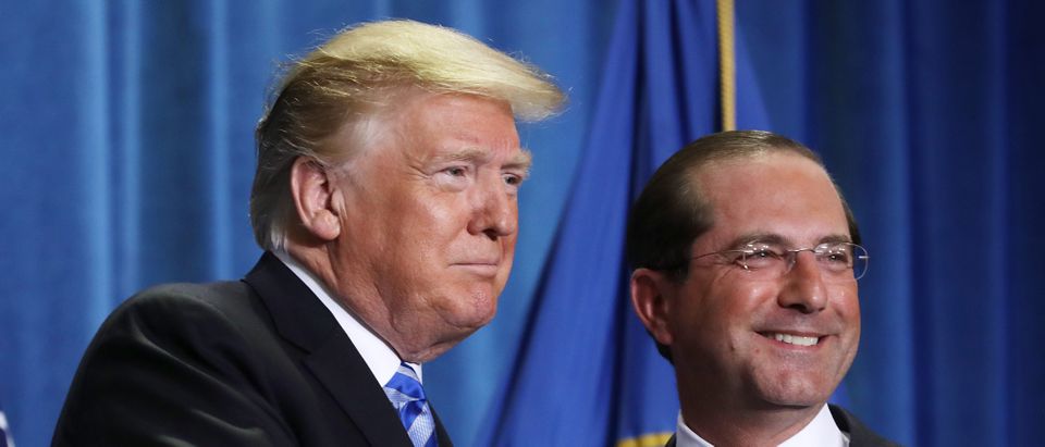 U.S. President Donald Trump (L) shakes hands with Health and Human Services Secretary Alex Azar before announcing a plan to overhaul how Medicare pays for certain drugs during a speech at HHS headquarters October 25, 2018 in Washington, DC. (Photo by Chip Somodevilla/Getty Images)