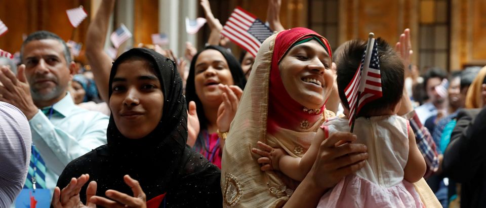 New citizens smile at a U.S. Citizenship and Immigration Services (USCIS) naturalization ceremony at the New York Public Library in Manhattan