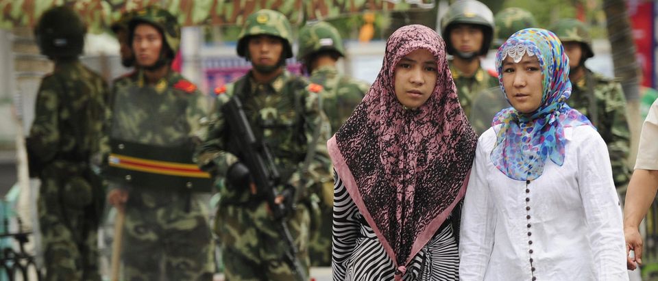 Two ethnic Uighur women pass Chinese par