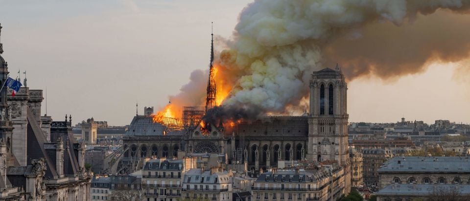 Smoke billows as flames burn through the roof of the Notre-Dame de Paris Cathedral on April 15, 2019, in the French capital Paris. (FABIEN BARRAU/AFP/Getty Images)
