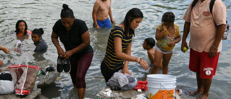 Migrants bathe in the Rio Grande near a makeshift encampment occupied by asylum seekers, most of whom were sent back to Mexico from the U.S. under the "Remain in Mexico" program officially named Migrant Protection Protocols (MPP), in Matamoros