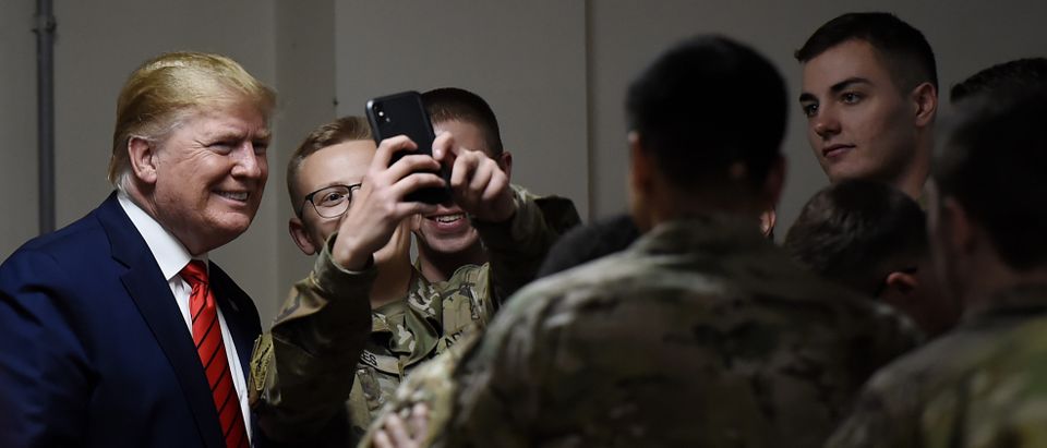 US President Donald Trump poses for selfies during a Thanksgiving dinner with US troops at Bagram Air Field during a surprise visit on November 28, 2019 in Afghanistan. (OLIVIER DOULIERY/AFP via Getty Images)