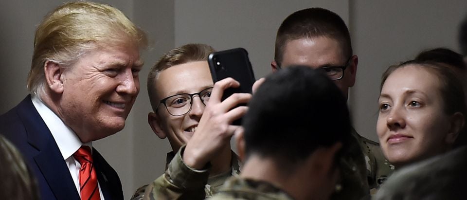 U.S. President Donald Trump poses for selfies during a Thanksgiving dinner with U.S. troops at Bagram Air Field during a surprise visit on Nov. 28, 2019 in Afghanistan. (Photo by OLIVIER DOULIERY/AFP via Getty Images)