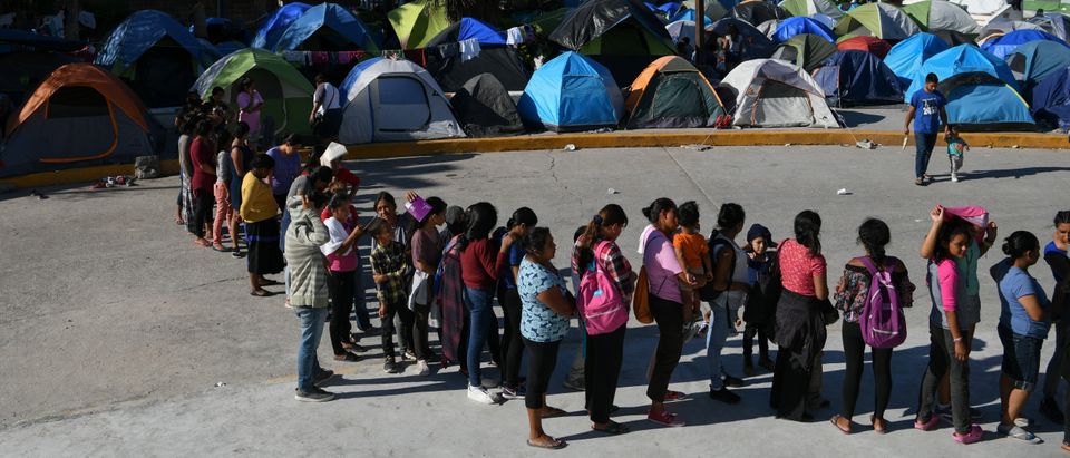Migrants, most of them asylum seekers sent back to Mexico from the U.S. under the "Remain in Mexico" program, officially named Migrant Protection Protocols (MPP), wait in line for a meal outside the Human Repatriation office in Matamoros